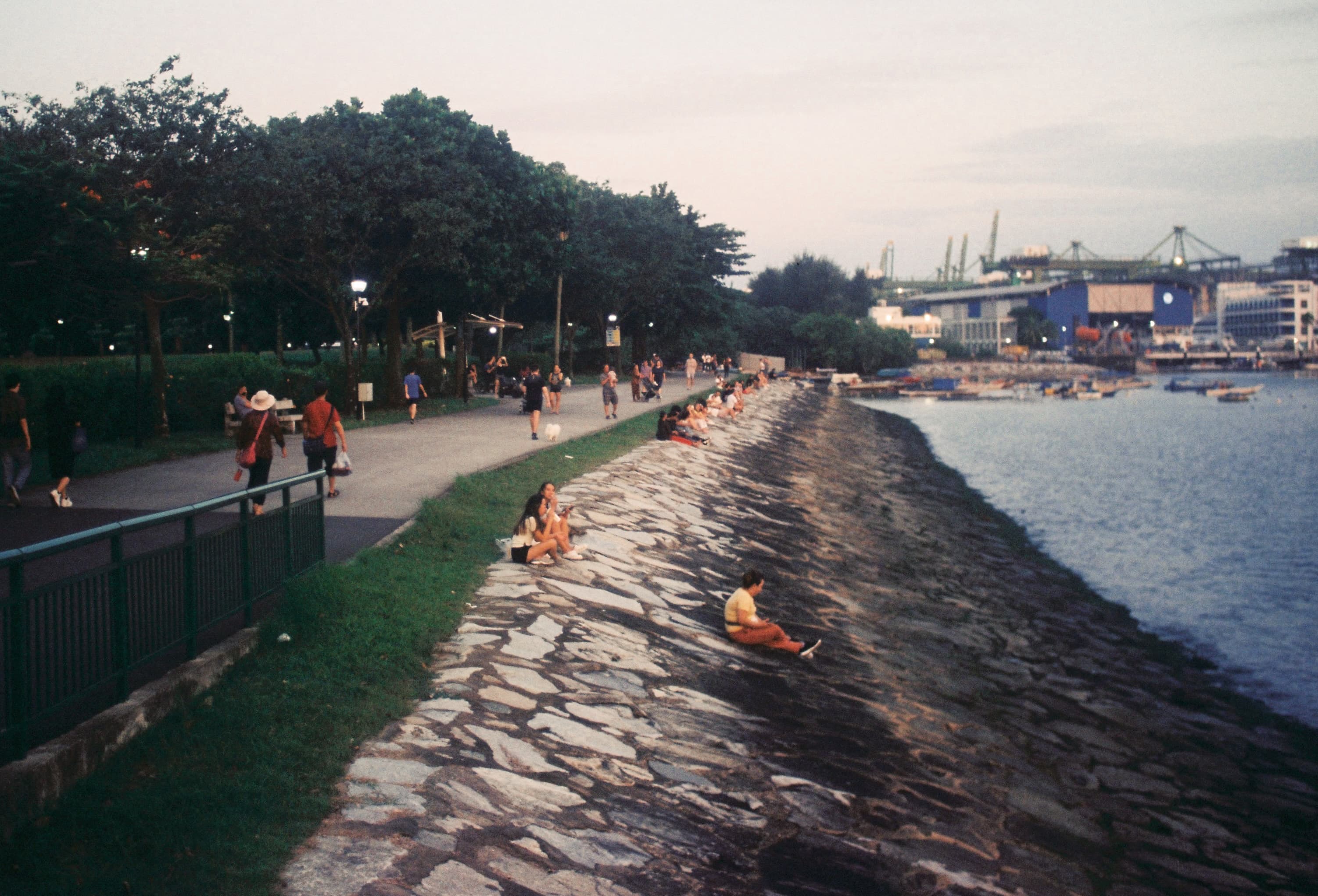 People gathered along a waterfront at dusk