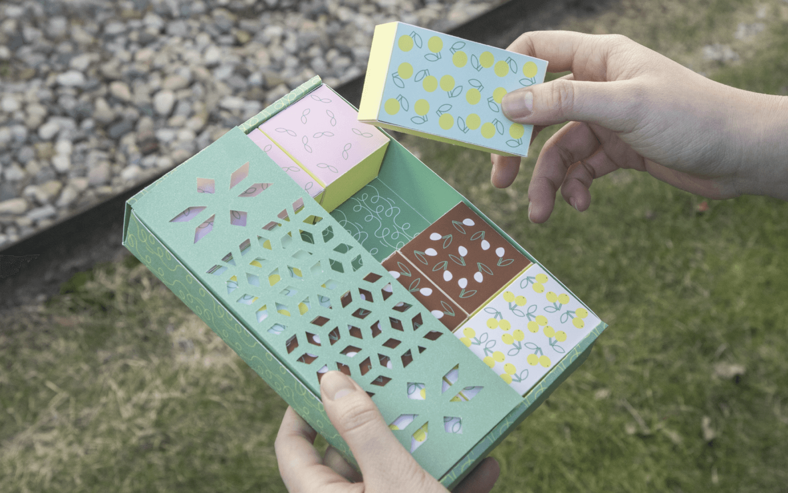 Hands opening the Fruit Series chocolate gift box outdoors